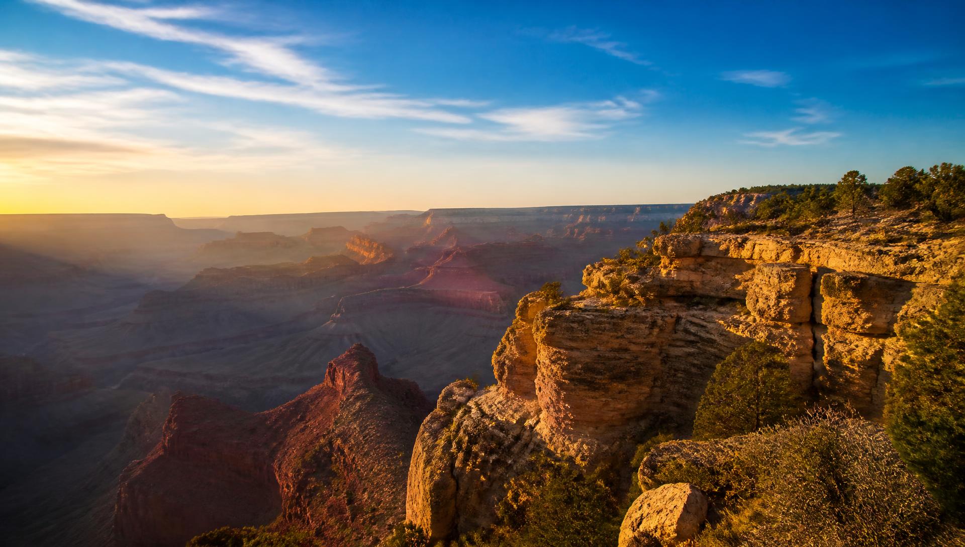Golden hour light across the layered cliffs of the Grand Canyon